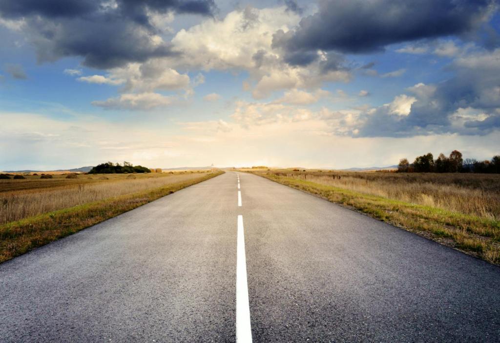 asphalt road under cloudy sky